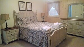 A bedroom with a bed, two bedside tables, a dresser, a mirror, and framed pictures on the wall. - CR-22 Harbeson Haven Peaceful 4 BR Chalet-Style Home Very well maintained (Beech Mountain)