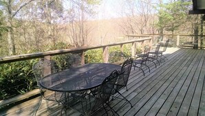 A wooden deck with a round metal table and four chairs. - CR-22 Harbeson Haven Peaceful 4 BR Chalet-Style Home Very well maintained (Beech Mountain)