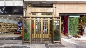 A storefront with a metal gate, a shoe display, and a green wall with plants. - 5 minutes from Copacabana beach | NSC906 (Rio de Janeiro)