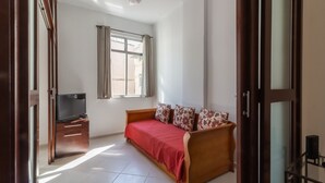 A bedroom with a bed, a TV on a stand, a window with curtains, and a ceiling fan. - 5 minutes from Copacabana beach | NSC906 (Rio de Janeiro)
