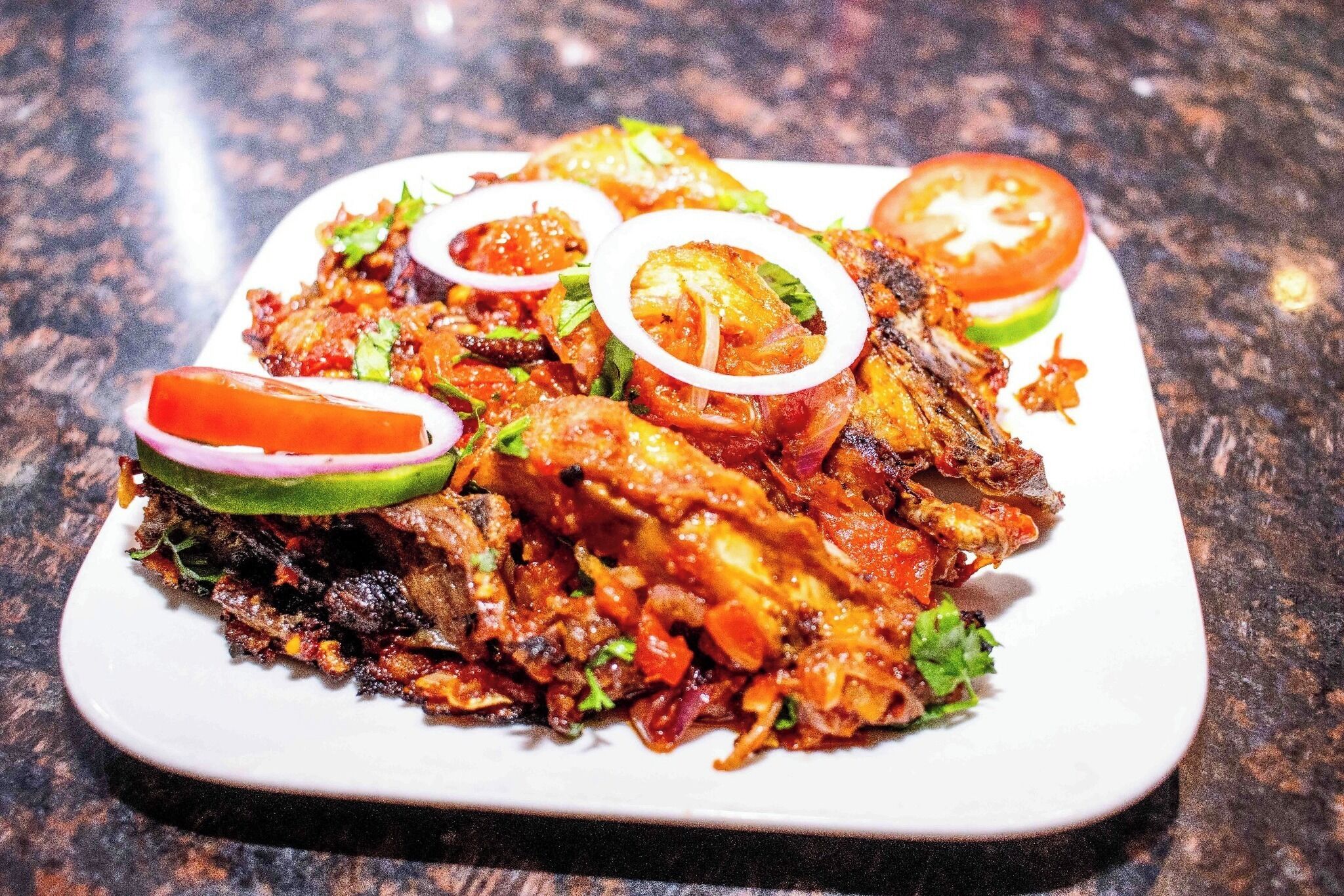 Un plato de pollo a la parrilla con vegetales y adornos.