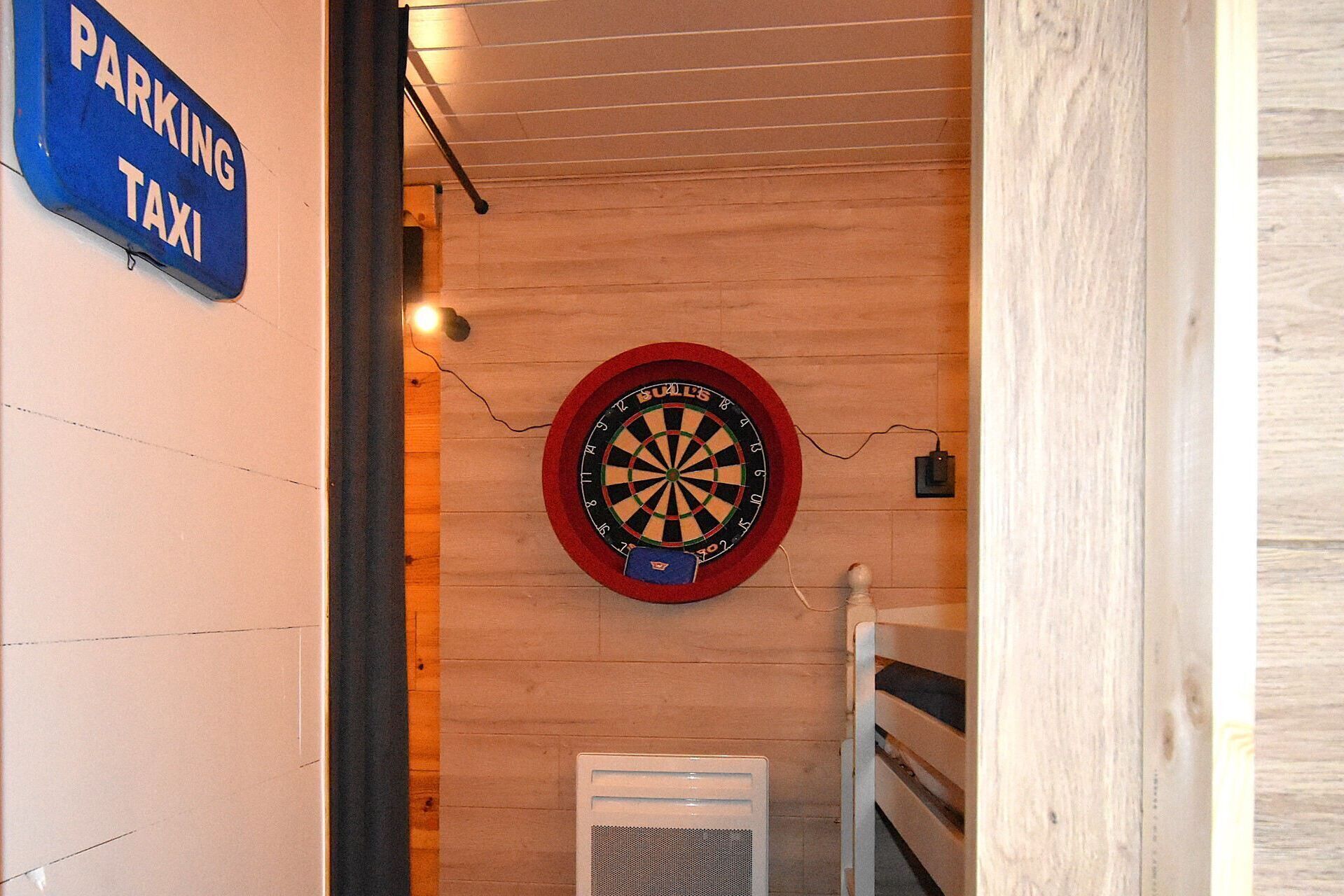 A dartboard mounted on a wooden wall with a sign indicating a parking area for taxis.