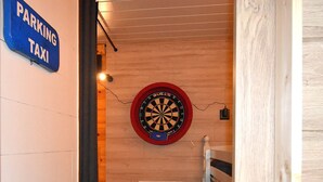 A dartboard mounted on a wooden wall with a sign indicating a parking area for taxis.