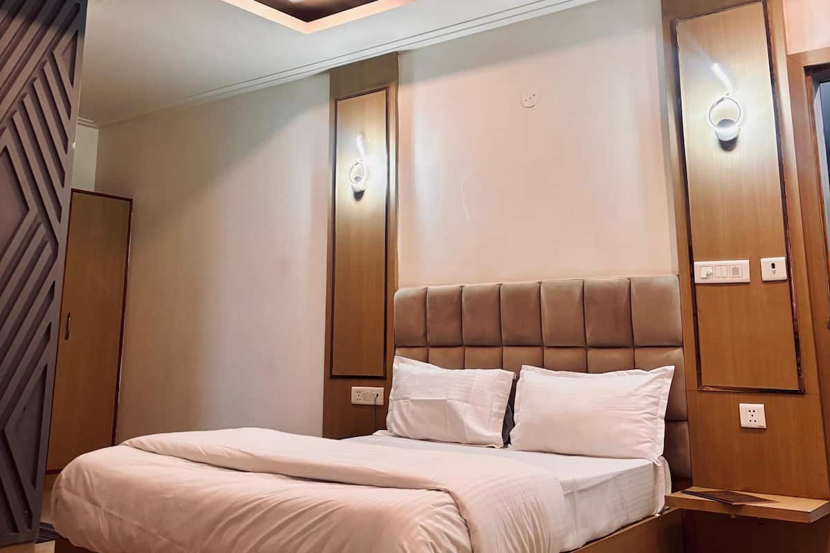 A modern bedroom with a large bed, a ceiling fan, and built-in lighting.