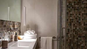 A modern bathroom with a large mirror, a white sink, and a glass shower enclosure. - San Nicolicchio (Taranto)