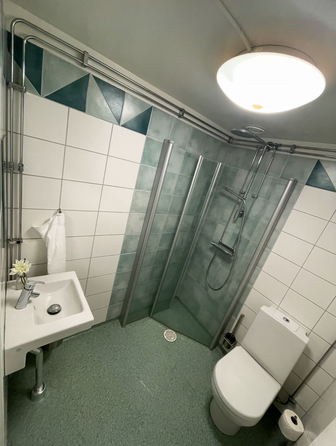 A compact bathroom with a shower, toilet, and sink.