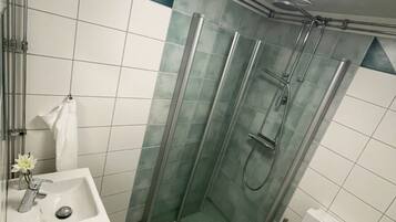 A compact bathroom with a shower, toilet, and sink.