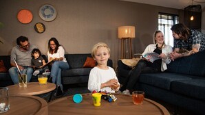 Een woonkamer met een bank, bijzettafeltje en een lamp.