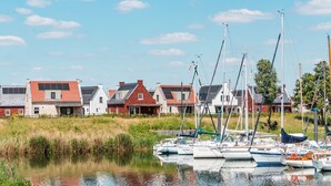A marina with several sailboats docked, surrounded by residential buildings with red and grey roofs. - Harbor View 4p - Two Bedroom Villa, Sleeps 4 (Thorn)