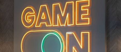 Un letrero de neón con las palabras 'GAME ON' en un estilo moderno e iluminado.