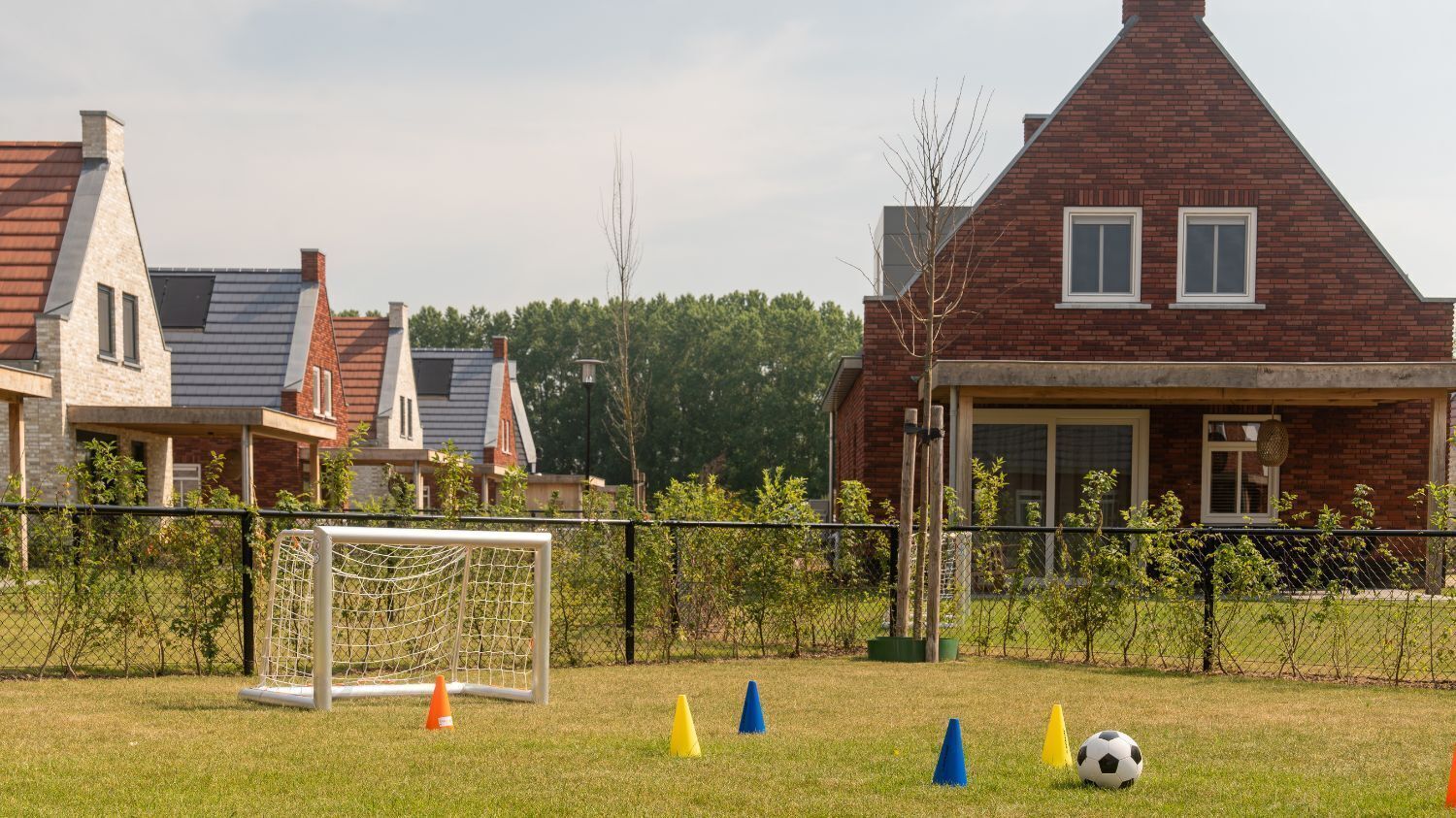 Een woonwijk met een huis, herkenbaar aan een zadeldak en een zichtbare garage.