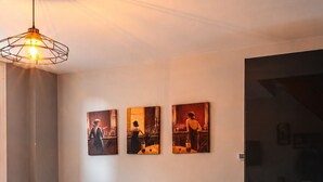 Una sala de estar moderna con un sofá, una obra de arte en la pared, una mesa de comedor dispuesta con platos, vasos y flores.