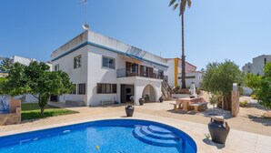 A modern two-story house with a swimming pool, outdoor furniture, and a palm tree. - Country House 'Ivone' with Sea View, Private Pool and Wi-Fi (Portimão)