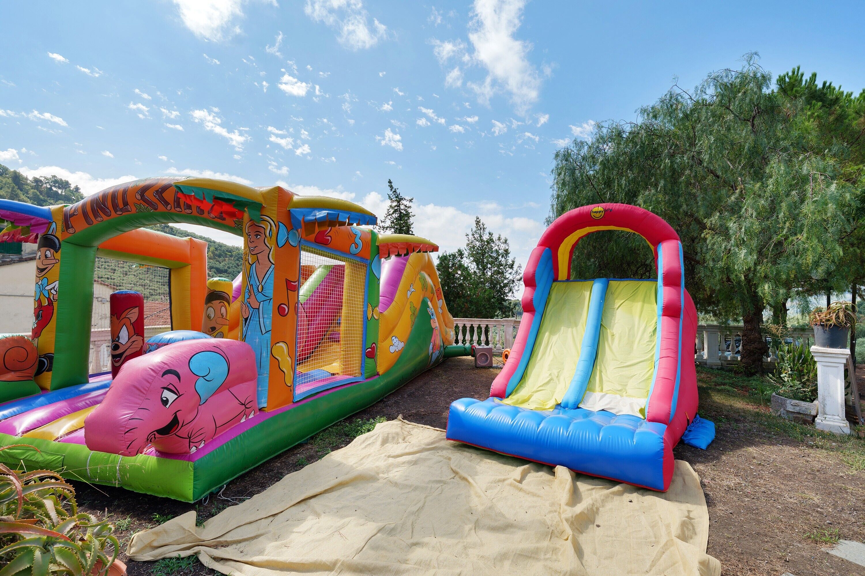 Un área de juegos inflable con toboganes y una estructura cubierta de red.