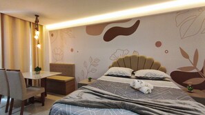 A hotel room with a bed, a small table, a chair, and a decorative wall. - Mila Rooftop - Praia de Tamandaré (Tamandaré)