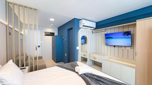 A hotel room with a bed, a TV, an air conditioner, a desk, and a wardrobe. - Mila Rooftop - Praia de Tamandaré (Tamandaré)