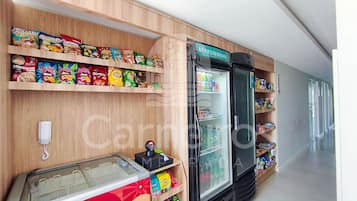 Exposição de petiscos com diversas marcas, uma seção refrigerada e um freezer.