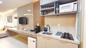 A modern kitchen with a built-in microwave, a coffee machine, and a sink. - Mila Rooftop - Praia de Tamandaré (Tamandaré)