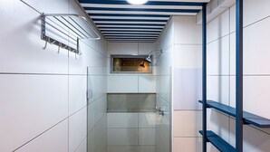 A narrow bathroom with a shower, a towel rack, and a ceiling light fixture. - Mila Rooftop - Praia de Tamandaré (Tamandaré)