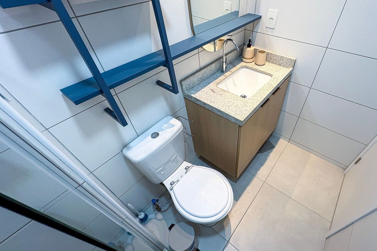 Ein kleines Badezimmer mit Toilette, Waschbecken und einem Hängeschrank.