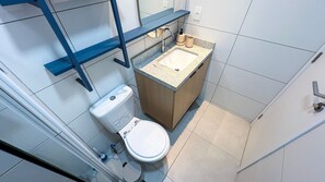 Ein kleines Badezimmer mit Toilette, Waschbecken und einem Hängeschrank.
