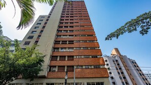 Un immeuble moderne et imposant, avec une façade combinant brique et béton, de nombreuses fenêtres et des balcons.
