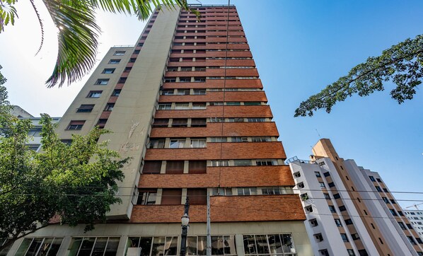 A tall, modern building with a mix of brick and concrete facades, multiple windows, and balconies. - Spacious Apartment in the Heart of SP - Brj143 (São Paulo)