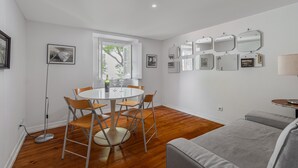 A dining area with a round table, chairs, and a floor lamp.