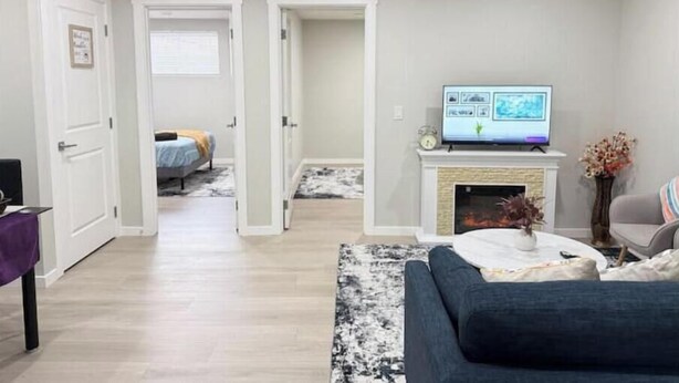 Ein Wohnzimmer mit einer Couch, einem Fernseher auf einem Kamin und einem Kamin.