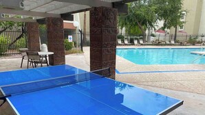 A ping pong table in an outdoor area with a pool in the background. - Scottsdale Getaway (Scottsdale)