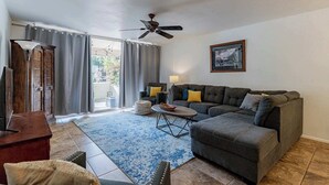 A living room with a sofa, ottoman, coffee table, and a ceiling fan. - Scottsdale Getaway (Scottsdale)