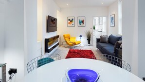 A modern living room with a sofa, a yellow chair, and a red rug.