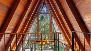 A wooden attic room with a large window and a view of the forest. - RJF - Comfortable Chalets in Urubici (Urubici)