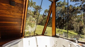 A wooden cabin interior with a large glass window offering a view of a forested hillside. - RJF - Comfortable Chalets in Urubici (Urubici)