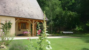 A house with a covered porch, a lawn, and a garden with flowers. - Near Sarlat in Périgord: Under the Linden Tree at Joelle and Guy’s – Country Room, Peace, Nature (Carsac-Aillac)