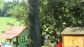 A wooden playhouse with a red roof, a green playhouse, and a small shed with a red roof. - Near Sarlat in Périgord: Under the Linden Tree at Joelle and Guy’s – Country Room, Peace, Nature (Carsac-Aillac)