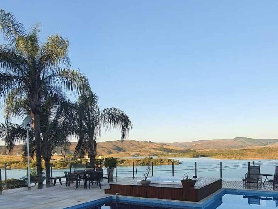 Una piscina al aire libre, sombrillas, sillones reclinables de piscina