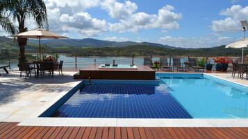 Een buitenzwembad, parasols voor strand/zwembad