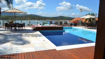 Een buitenzwembad, parasols voor strand/zwembad