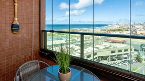 A room with a large window overlooking a beach and cityscape. - Sea View 2Bedroom Apartment on Salvador’s Shore (Salvador)