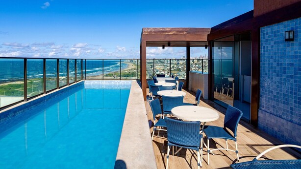 A rooftop pool area with a clear view of the ocean and cityscape. - Sea View 2Bedroom Apartment on Salvador’s Shore (Salvador)