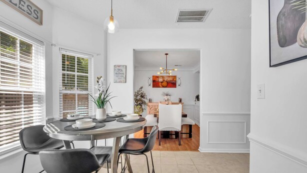A dining area with a round table, chairs, and a pendant light. - Updated University Area Home with Hot Tub Near Charlotte Your Perfect Retreat! (Charlotte)