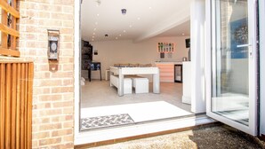 Un interior moderno con mesa de billar, sofá y comedor.