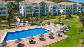 A resort with a swimming pool, lounge chairs, and a well-maintained lawn. - Golfer’s Paradise! Spacious Apt in La Cala Golf | Pass the Keys (Mijas)