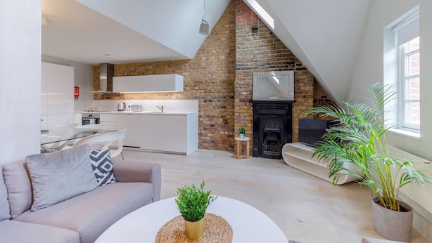 Un moderno apartamento tipo loft con cocina, sala de estar y chimenea.