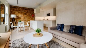 Una sala de estar moderna con un sofá, una mesita de centro y una pared de ladrillo.