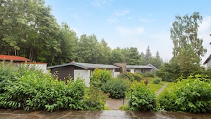 Un quartier résidentiel avec des allées pavées de pierres, une végétation luxuriante et des maisons aux toits de styles différents.
