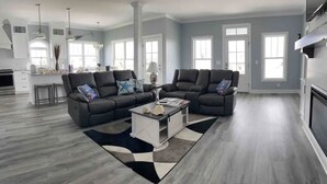 Un salon spacieux avec un canapé d’angle, une table basse et une cheminée.