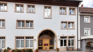A multi-story building with a central entrance, multiple windows, and a wheelchair-accessible ramp. - Apartment 'Südschwarzwald' with Balcony and Wi-Fi (Bräunlingen)