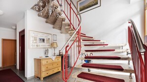 A staircase with red railings, wooden steps, and red carpeted risers. - Apartment 'Südschwarzwald' with Balcony and Wi-Fi (Bräunlingen)
